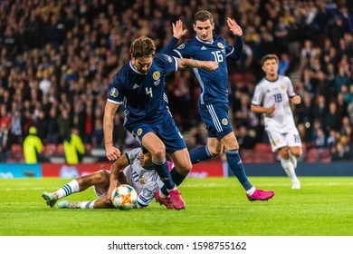 Glasgow, United Kingdom – September 6, 2019. Scotland Players Kenny McLean And Charlie Mulgrew Against Russia Midfielder Ilzat Akhmetov During UEFA Euro 2020 Qualification Match Scotland Vs Russia