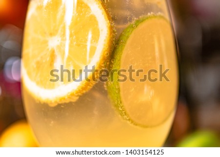 Glass of alcoholic cocktail with slice of lemon and lime