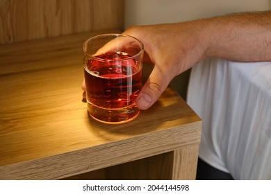 A Glass Of Alcoholic Drink In The Hands Of A Close-up Of A Man. A Man Drinks Alcohol In A Hotel Room Or At Home. Tasting Spirits Such As Scotch, Brandy Or Whiskey