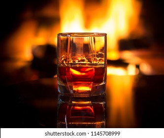 Glass of alcoholic drink wine in front of warm fireplace. Magical relaxed cozy atmosphere near fire - Powered by Shutterstock