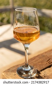 Glass Of Amber Wine On Wooden Table