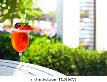 Glass of Aperol Spritz cocktail on the cafe table at the tropical resort