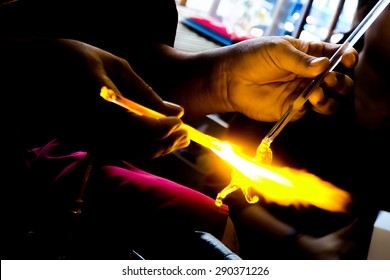 Glass artist in his workshop. Making glass beads in traditional style