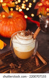 A glass of autumn pumpkin latte with whipped cream and spices. Coffee with pumpkin and cinnamon on a dark background, bokeh lights, vertical photo. High quality photo - Shutterstock ID 2200707155