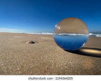 A Glass Ball On A Sandy Bay