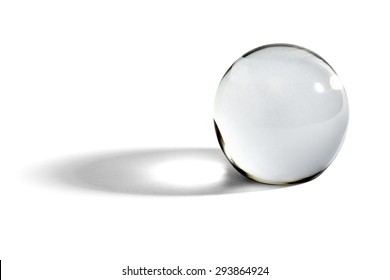 Glass ball or orb for fortunetelling, soothsaying and predicting the future with a shadow on a white background with copy space