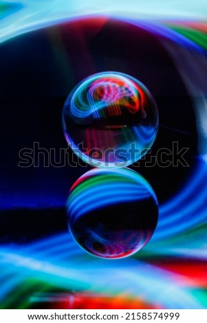 A glass ball with a reflection isolated on a colorful background