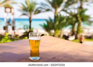 A glass of beer against the backdrop of the sea.