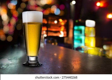 Glass Of Beer With Bar Scene In The Background