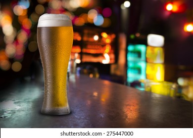 Glass Of Beer With Bar Scene In The Background