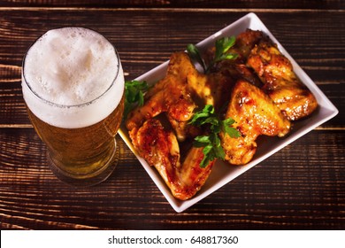 Glass of beer and buffalo chicken wings. Beer bites. View from above, top studio shot