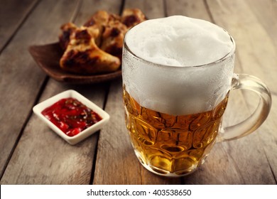 Glass Of Beer And Chicken Wings On Wooden Table, Close Up