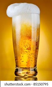 Glass Of Beer With Froth Over Yellow Background