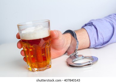 Glass Of Beer With Handcuffs As Symbol For Alcohol Abuse