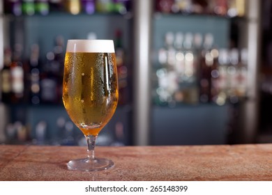 Glass of beer on the marble bar stand