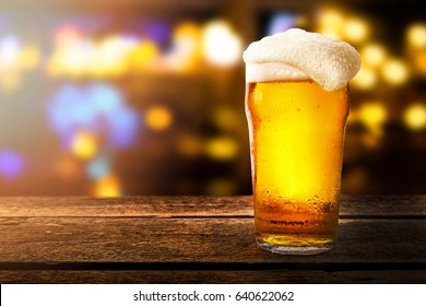 glass of beer on a table in a bar on blurred bokeh background - Shutterstock ID 640622062