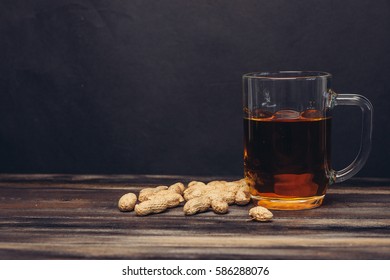 glass of beer peanuts on the table