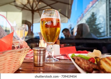 Glass Of Beer And Street Food On A Cafe Table.