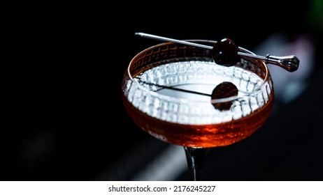 A Glass Of Black Cherry Cocktail On A Black Background