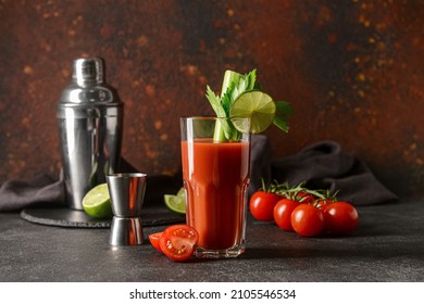 Glass of bloody mary with celery, lime and tomatoes on table
