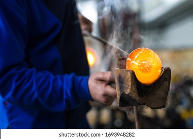 Glass Blower Forming Beautiful Piece Of Glass. A Glass Crafter Is Burning And Blowing An Art Piece. 