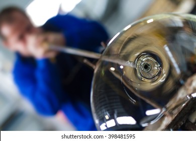 Glass Blower Forming Beautiful Piece Of Glass. A Glass Crafter Is Burning And Blowing An Art Piece. 