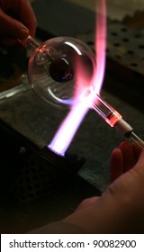 Glass blower forming a piece of decorative glass.