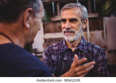 Glass blower interacting with each other at glass blowing factory - Powered by Shutterstock