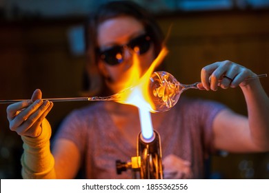 A glass blower melting glass