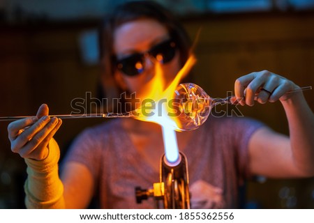 A glass blower melting glass