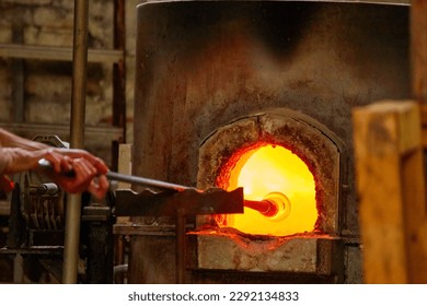 A Glass Blower Shaping Molten Glass into a Piece of Art - Powered by Shutterstock