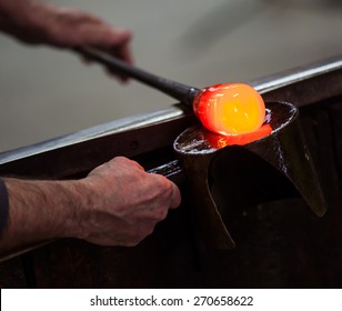 Glass blower at work shaping molten glass, Murano, Venice, Italy