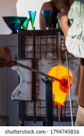 A Glass Blowing Artist Rotating His Art Piece In The Fire Of A Kiln