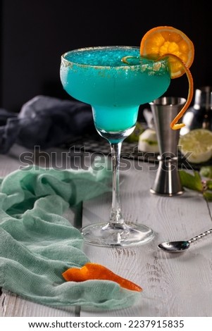 A glass of blue cocktail on a white background