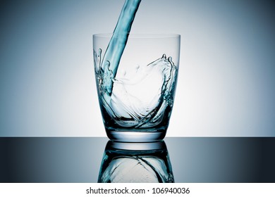 Glass With Blue Liquid Pouring In