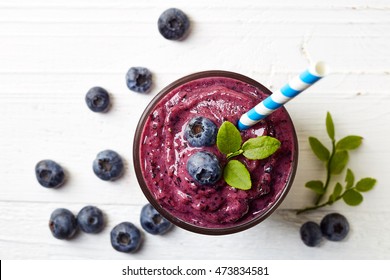 Glass Of Blueberry Smoothie On White Wooden Background From Top View