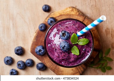 Glass Of Blueberry Smoothie On Wooden Background From Top View