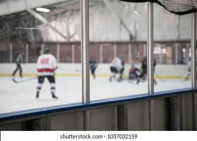 Glass Boards At An Ice Hockey Rink With Blurry Players Behind