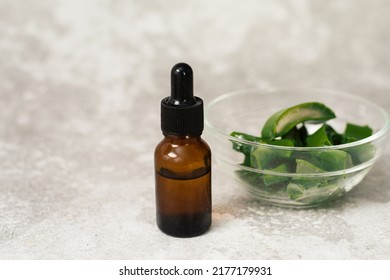 Glass Bottle With Aloe Gel Serum On Gray Background With Copy Space.