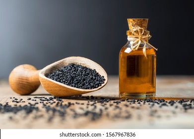 glass bottle of black cumin seeds essential oil , Nigella Sativa in spoon on wooden background. Organic herbal medicine for many diseases, black cumin - Shutterstock ID 1567967836