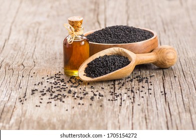 glass bottle of black cumin seeds essential oil , Nigella Sativa in spoon on wooden background. Organic herbal medicine for many diseases, black cumin - Shutterstock ID 1705154272