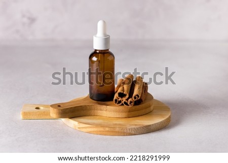 Glass Bottle with Essential Cinnamon Oil and Sticks on Wooden Board Gray Background ストックフォト © 