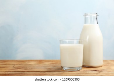 Glass and bottle with fresh milk on table against color background. Space for text - Shutterstock ID 1269508303