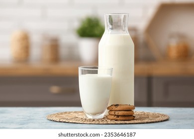 Glass and bottle of fresh milk with sweet cookies on blue table in kitchen - Powered by Shutterstock