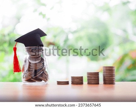 Glass bottle with graduation hat and stack of coins. The concept of saving money for education, student loan, scholarship, tuition fees in future