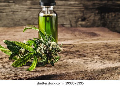 Glass bottle with herbal organic medicine CBD concentrate, droplet dosing a biological and ecological hemp plant herbal pharmaceutical cbd oil from a jar and medical cannabis bud on wooden background.