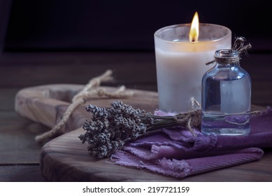 Glass Bottle Lavender Essential Oil Dried Seed  Aromatherapy Spa Massage Concept. Herb Purple Candle Wood Table Background Sea Salt Still Life Rustic Cutting Board Napkin.