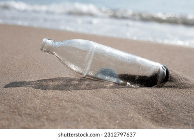 Glass bottle on the beach - Shutterstock ID 2312797637