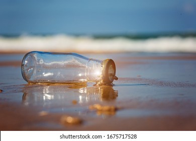 glass bottle on the beach.Trash on the beach. Reduce waste in the sea, Ecological and environmental problems. - Shutterstock ID 1675717528