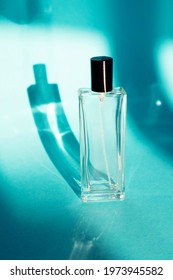 Glass Bottle On A Turquoise Background With A Shade From The Sun. Summer Marine Unisex Perfume Concept